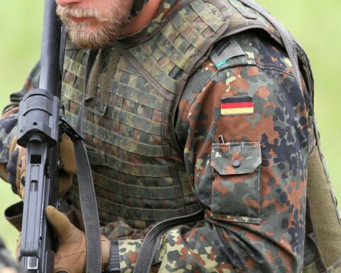 Bundeswehr-Soldat diskutiert NATO-Einsatz zur Friedenssicherung in der Ukraine, unterstrichen durch politische Debatte.