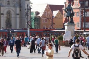 Marktplatz in Halle: Menschen, die Lebenszufriedenheit und Zukunftsängste symbolisieren. Hoffnung und Sorgen vereint.