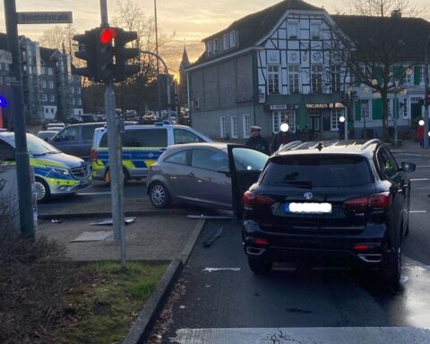 Unfallstelle mit zwei beschädigten Autos und einem Streifenwagen in Hückeswagen.