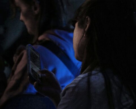 Junge Frau mit Smartphone, symbolisiert digitale Kommunikation und die Diskussion um Datenspeicherung.