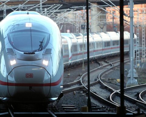ICE-Zug auf Gleisen, umgeben von winterlicher Landschaft, symbolisiert reibungslosen Weihnachtsreiseverkehr.