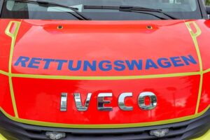 Rettungswagen an Unfallstelle, beschädigte Fahrzeuge, Polizei ermittelt, Zeugen gesucht.