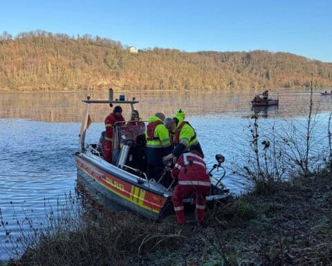 Rettungsboote der Feuerwehr und DLRG bei Wasserrettungseinsatz am Baldeneysee, Eisdecke sichtbar.