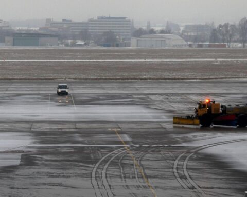 Vereiste Landebahn mit Schnee, winterlicher Hintergrund, Signal für Glättegefahr und starke Winde.