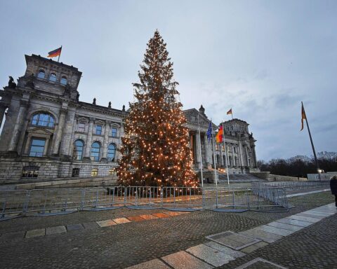 Bundestagsgebäude mit wechselhaftem Wetter: Sonne, Wolken, Regen und milde Temperaturen in Berlin.