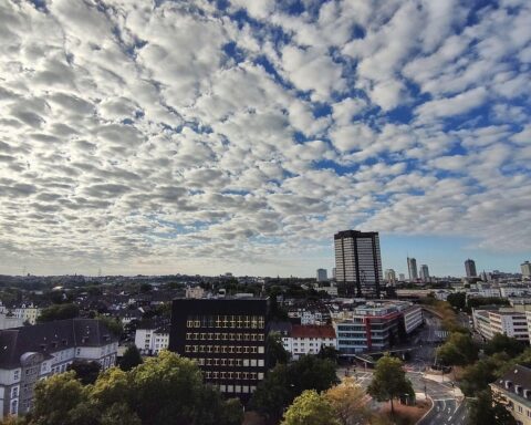Grauer, bewölkter Himmel über Essen, milde Temperaturen und vereinzelte Regenfälle anzeigen.