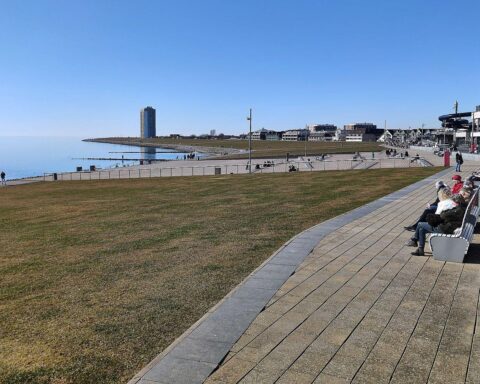 Promenade in Büsum bei sonnigem Wetter mit Wolken und kühler Temperatur.