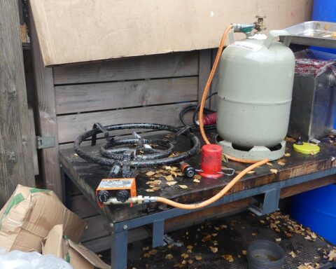 Das Bild zeigt eine beschlagnahmte, mutmaßlich illegale Shisha-Tabak-Anlage mit Materialien und Maschinen.