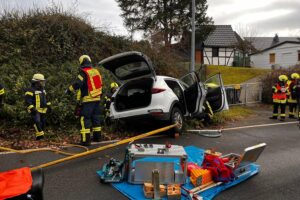 Verkehrsunfall mit Verletzten, Feuerwehr im Einsatz, Rettungskräfte sichern Fahrzeug und retten Insassen.
