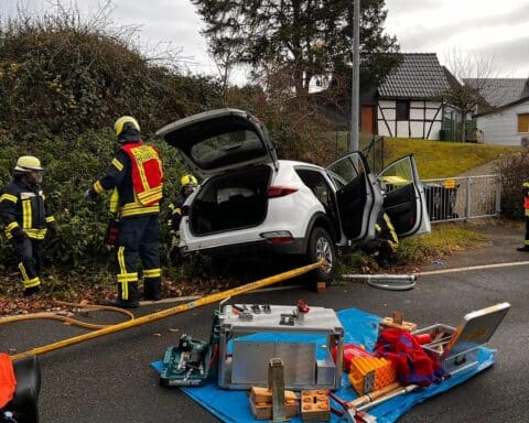 Verkehrsunfall mit Verletzten, Feuerwehr im Einsatz, Rettungskräfte sichern Fahrzeug und retten Insassen.