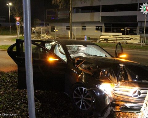 Unfallfahrzeug in Oberhausen, Polizei und Rettungsdienst im Einsatz, verletzte Person wird versorgt.