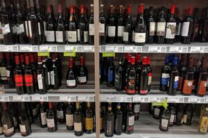 Eine Flasche Rotwein auf einem Tisch, umgeben von Gläsern und einer gemütlichen Atmosphäre.