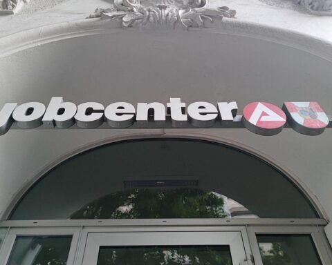 Jobcenter mit Arbeitsuchenden, umgeben von Informationen zur Arbeitslosigkeit in Sachsen-Anhalt.