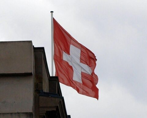 Schweizer Flagge vor schockierenden Nachrichten über Explosion in Crans-Montana während Silvesterfeier.