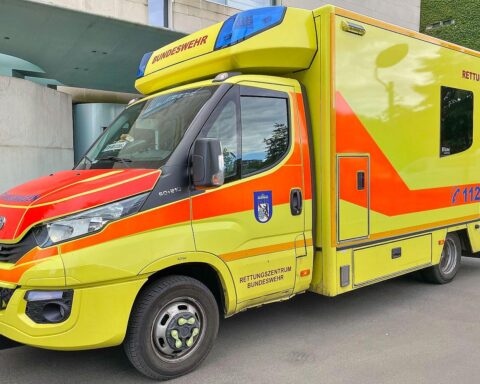 Rettungswagen und Passanten helfen nach schwerem Unfall in Berlin-Alt-Treptow.