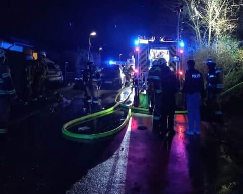 Balkonbrand in Hochhaus, Feuerwehr im Großeinsatz, Bewohner evakuiert, Rettungskräfte im Einsatz.