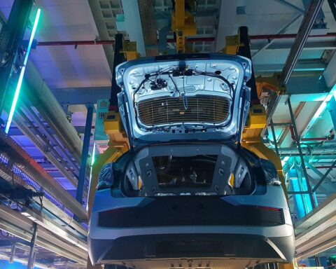 E-Autos auf einem Montageband, Symbol für Zukunft und elektrische Mobilität, mit Förderungen und Steuervorteilen.