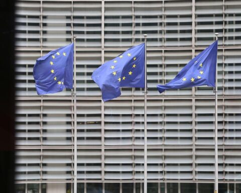 EU-Fahnen symbolisieren Maßnahmen gegen Elon Musks KI-Chatbot Grok und dessen problematische Inhalte.