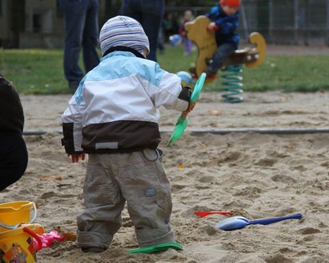Kleinkind auf Spielplatz, Symbol für Bürgerentscheid für Erhalt des Spiel- und Parkplatzes.