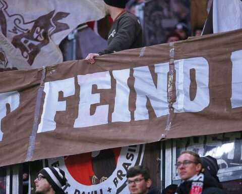 Fans im Millerntor-Stadion während des Stadtderbys, Sicherheitskräfte überwachen friedliches Event.