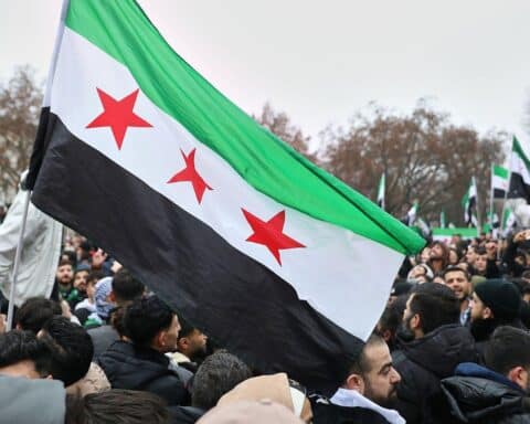 Syrien-Fahne mit Symbolik für Frieden und Integration zwischen Regierung und kurdischen Kräften.