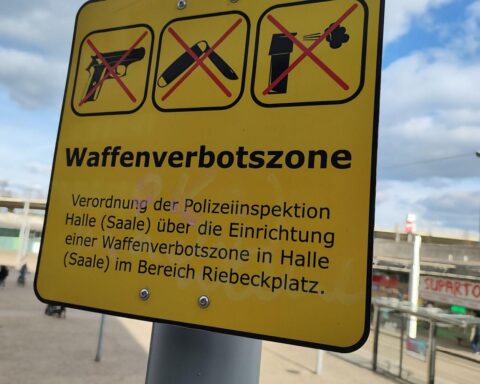 Symbolbild einer Waffenverbotszone: Sicherheitssymbole, Städte, Menschen in Schutzmaßnahmen, klare Warnhinweise.