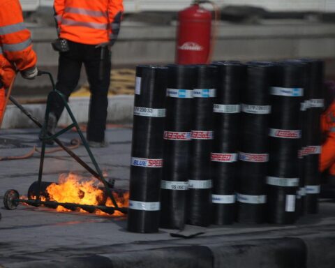 Bauarbeiter bei der Arbeit, symbolisiert wirtschaftliche Herausforderungen und Gesetzesänderungen im Bauwesen.