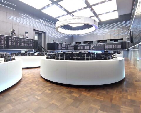 Frankfurter Börse mit Dax-Anzeige und Handelsaktivität, symbolisierend positive Marktentwicklung.