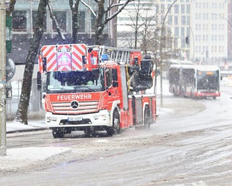 Feuerwehr in Hamburg zeigt Einsatzkräfte im Schnee während einer Unwetterwarnung.