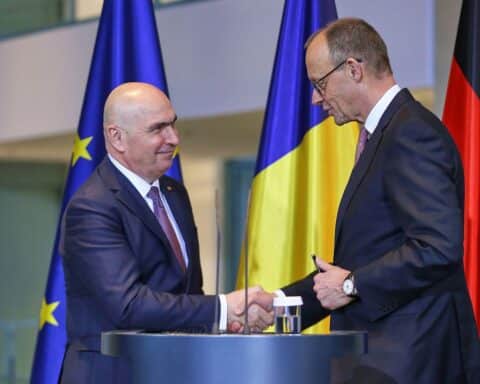 Friedrich Merz und Ilie Bolojan bei Pressekonferenz zu Rüstungskooperation in Berlin.