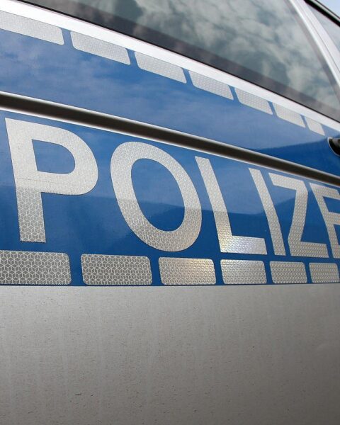 Polizeiauto an einer Unfallstelle mit Bergungsarbeiten und abgesperrter Straße.