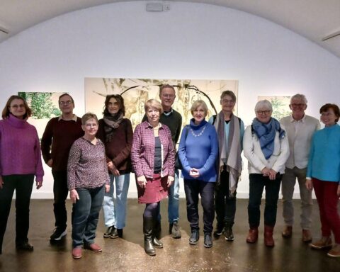 Ehrenamtliche betrachten Kunstwerke in der Ausstellung "Lifeline" im Donauschwäbischen Zentralmuseum.