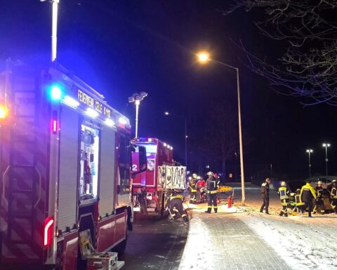 Feuerwehr befreit Fahrer aus Unfallfahrzeug, Unfallstelle mit beschädigter Laterne sichtbar.