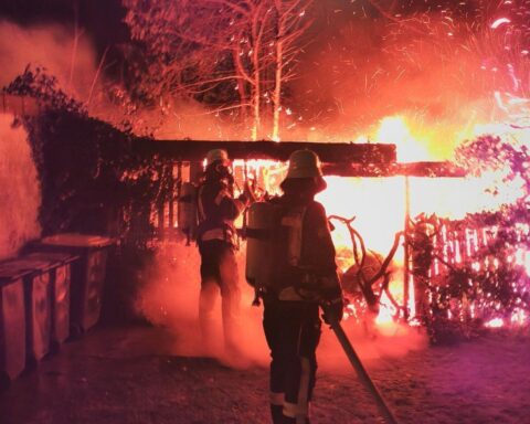 Feuerwehr Löscharbeiten am Holzschuppen in Celle, Silvesterfeuer, hektische Einsatzszene.