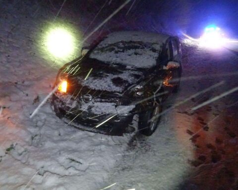 Unfallfahrzeug auf der A57, Feuerwehr sichert Einsatzstelle, verletzte Person wird behandelt.