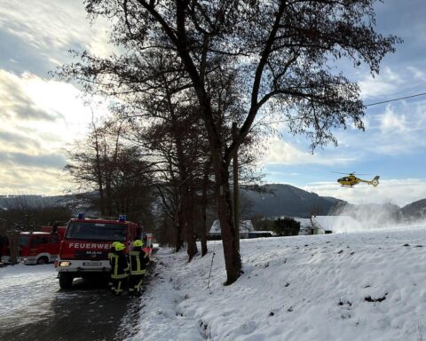 Feuerwehr beim Wohnungsbrand: Rettung verletzter Person, Löscharbeiten und Einsatzkräfte vor Ort.