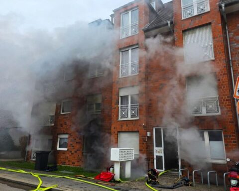 Feuerwehr rettet Bewohner aus brennendem Wohnhaus mit Leitern und Atemschutzgeräten.