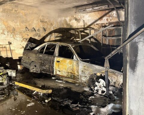 Ausgebrannter PKW in Garage, Feuerwehr bei Löscharbeiten, Anzeichen eines nächtlichen Brandes.