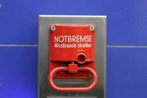 Eine Frau zieht Notbremse im fahrenden ICE, Fensterscheiben beschädigt, Polizei alarmiert.