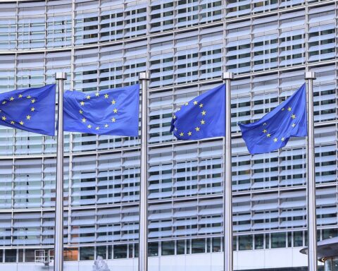 EU-Fahnen im Vordergrund, symbolisieren Unterstützung für Menschenrechtsbewegung im Iran gegen die Revolutionsgarde.