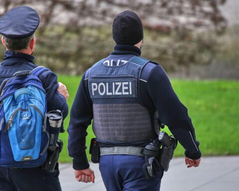 Zwei Bundespolizisten sichern das Kanzleramt, während Bauarbeiten für Erweiterungsbau fortschreiten.