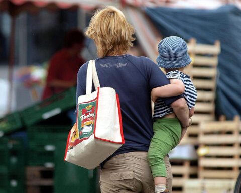 Frau hält Neugeborenes, symbolisiert Geburtenstatistik in Hamburger Krankenhäusern und Geburtshäusern.