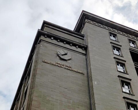 Ein modernes Handwerksgebäude mit Handwerkern bei der Arbeit, symbolisiert das Handwerk und Erbschaftsthemen.