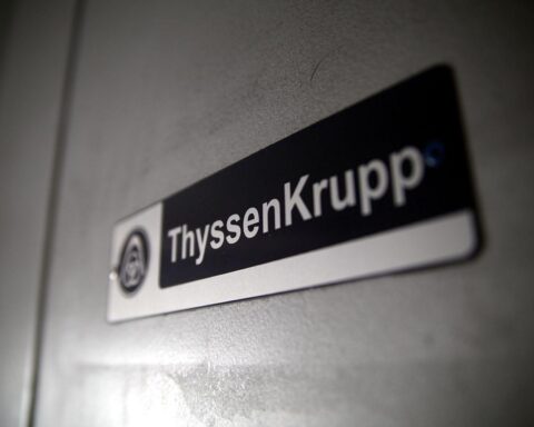 Stahlwerk mit Arbeitern, Maschinen und IG Metall-Logo, symbolisiert Unsicherheit und Zukunft von Thyssenkrupp.