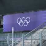 Olympische Ringe vor dem Hintergrund einer Stadt, symbolisieren Hamburgs Entscheidung gegen die Olympia-Bewerbung.