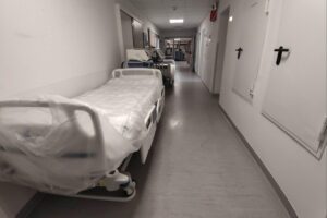 Ein besorgter Arzt im Krankenhaus, der über Kriegsvorbereitung und Gesundheitsversorgung nachdenkt.