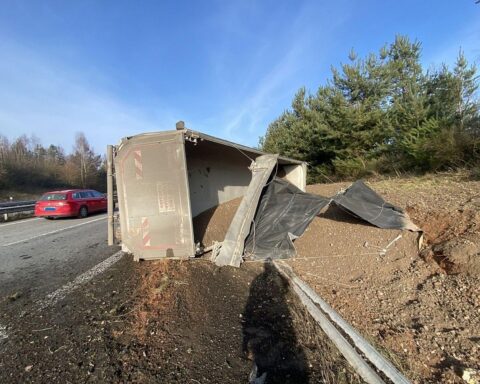 Ein umgekippter Kipplaster auf der Autobahn 63 bei Sembach, Polizeieinsatz im Hintergrund.