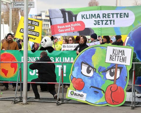 Demonstranten halten Plakate und Banner, die für Klimaschutz und nachhaltige Politik werben.