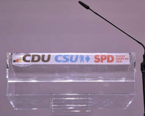 Rednerpult mit Logos von CDU, CSU und SPD, Symbol für politischen Mitgliederschwund.
