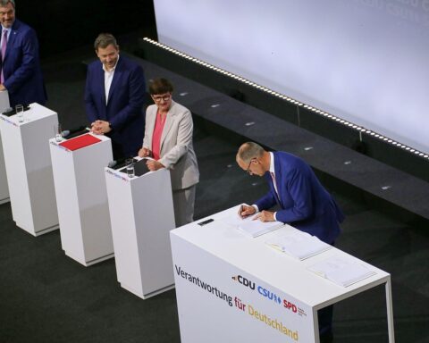 Politiker unterzeichnen Koalitionsvertrag; symbolisieren Zusammenarbeit zwischen CDU, CSU und SPD in Deutschland.